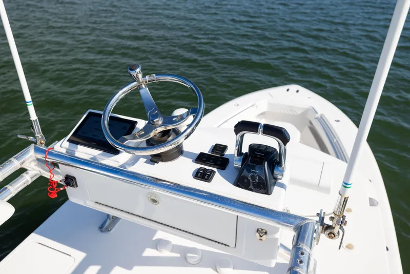 Slide: The Image of 2015 Invincible 39 Open Fisherman boat helm with steering wheel and controls on water. - 36