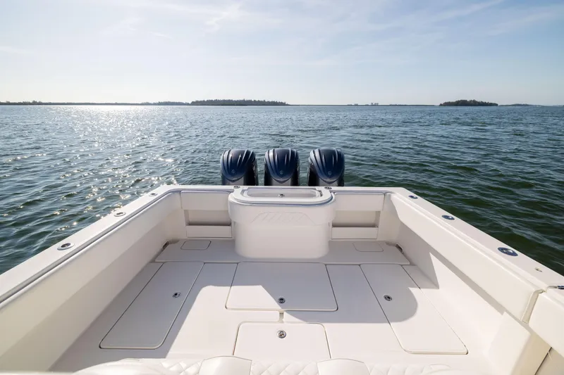 Slide: The Image of 2015 Invincible 39 Open Fisherman boat on calm water, featuring triple outboard engines. - 38
