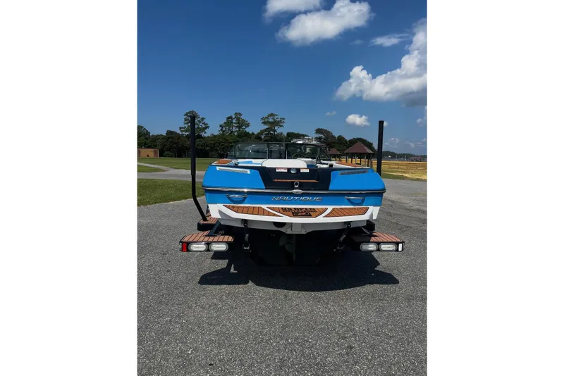 Slide: The Image of 2015 Nautique Ski Nautique 200 Open Bow boat, rear view, parked outdoors. - 3