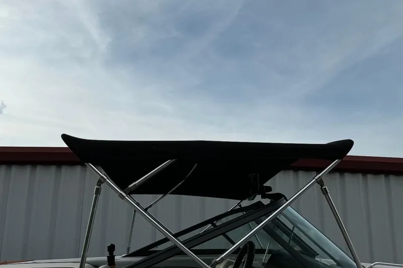 Slide: The Image of 2015 Nautique Ski Nautique 200 Open Bow with bimini top against cloudy sky. - 7