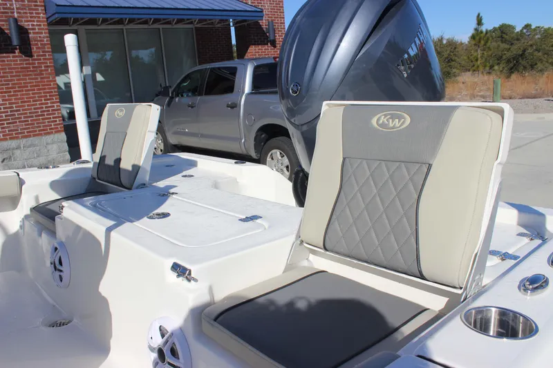 Slide: The Image of 2026 Key West 210 Bay Reef boat interior with cushioned seats and motor. - 21