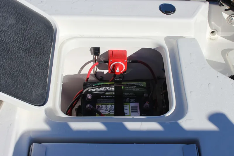 Slide: The Image of Battery compartment of 2026 Key West 210 Bay Reef boat with marine battery and switch. - 24