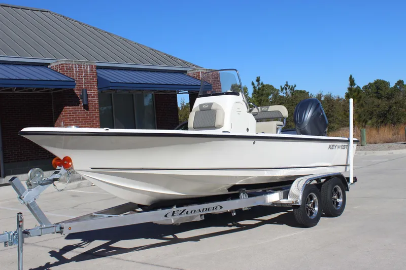 Slide: The Image of 2026 Key West 210 Bay Reef boat on trailer, parked outside a building. - 3
