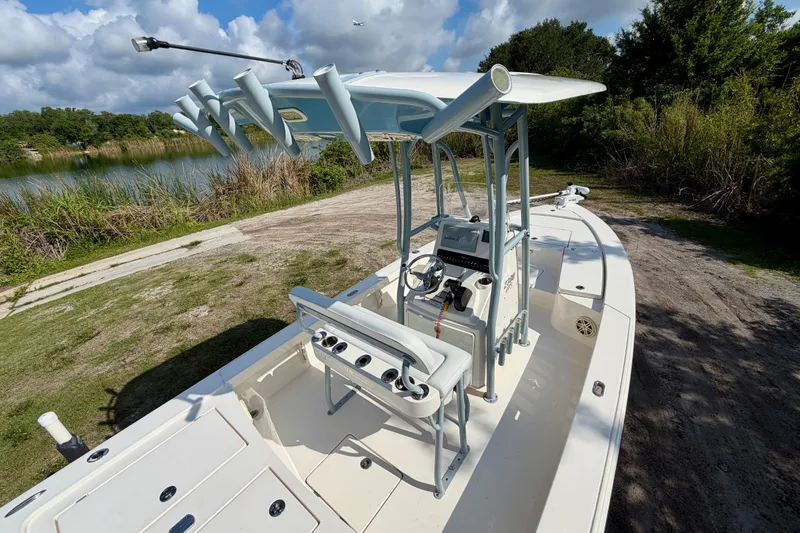 Slide: The Image of 2020 Pathfinder 2300 HPS boat with center console, rod holders, and scenic lake backdrop. - 10