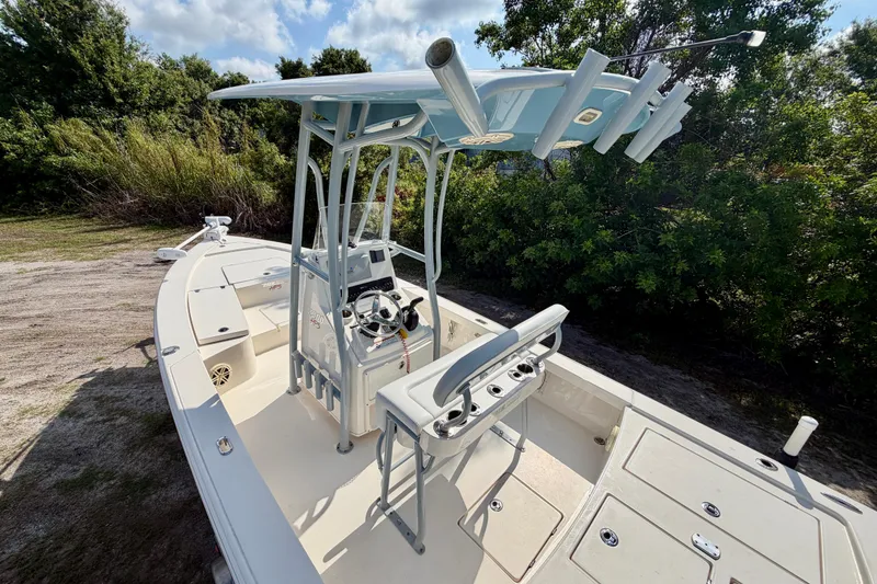 Slide: The Image of 2020 Pathfinder 2300 HPS boat with center console and rod holders, parked outdoors. - 11