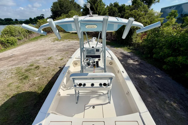 Slide: The Image of 2020 Pathfinder 2300 HPS boat with T-top, parked on a grassy area near trees. - 13