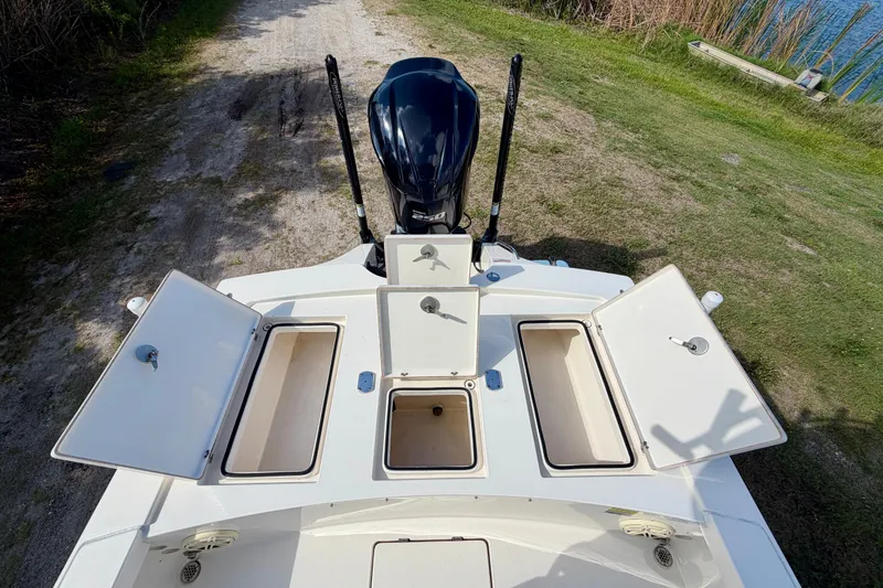 Slide: The Image of 2020 Pathfinder 2300 HPS boat with open storage compartments and outboard motor. - 16