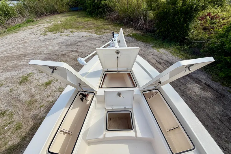 Slide: The Image of Open storage compartments on a 2020 Pathfinder 2300 HPS boat, surrounded by greenery. - 18