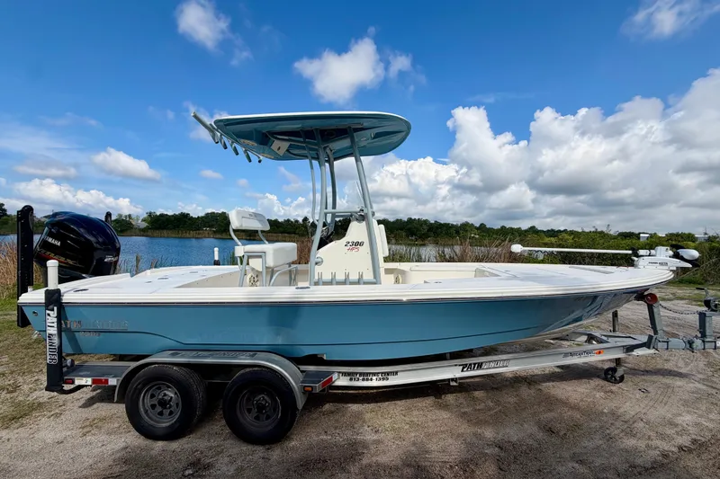 Slide: The Image of 2020 Pathfinder 2300 HPS boat on trailer by a lake under blue sky. - 4