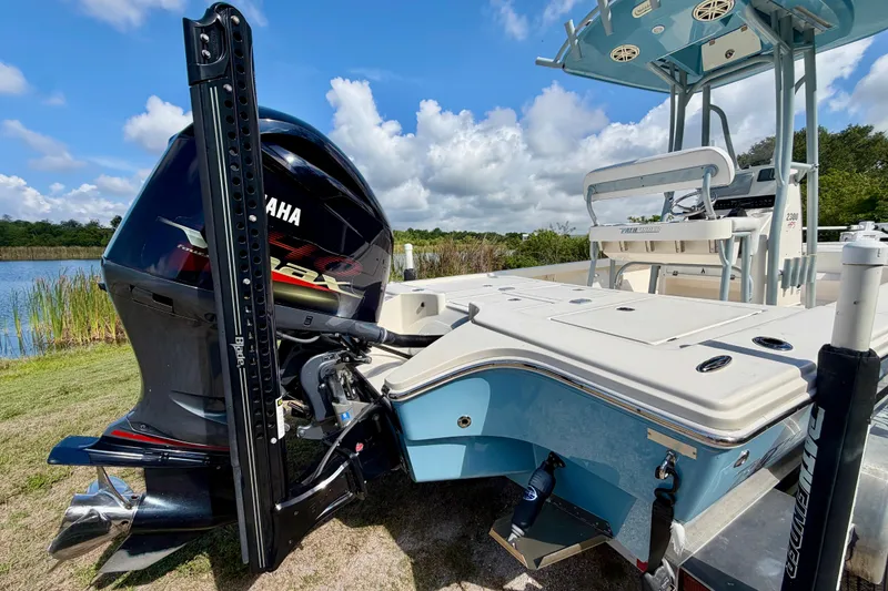 Slide: The Image of 2020 Pathfinder 2300 HPS boat with Yamaha engine, docked by a serene lake. - 5