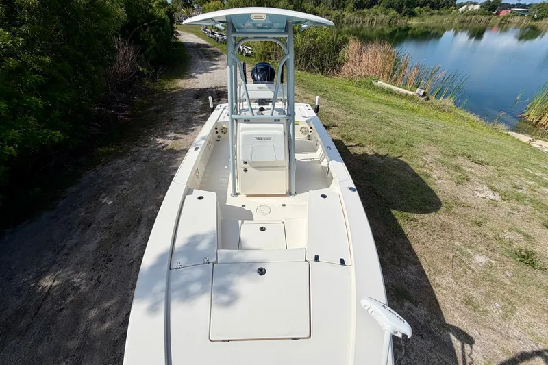 Slide: The Image of 2020 Pathfinder 2300 HPS boat on grassy lakeside path, clear sky reflection. - 7