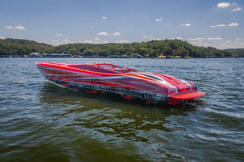 Slide: The Image of Red 2004 Outerlimits 42 Legacy speedboat on a lake, surrounded by scenic greenery. - 45