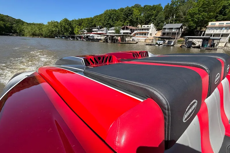 Slide: The Image of Red and black 2004 Outerlimits 42 Legacy boat cruising on a scenic river. - 10