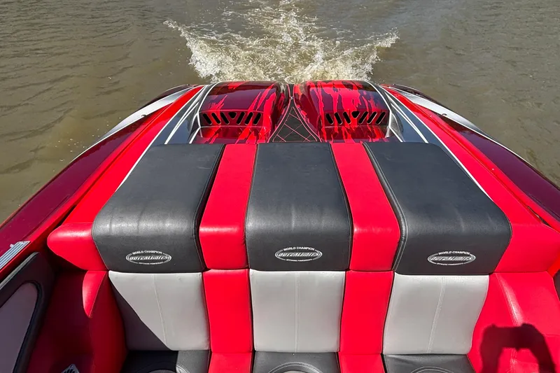 Slide: The Image of 2004 Outerlimits 42 Legacy boat with red and black seating, cruising on water. - 11