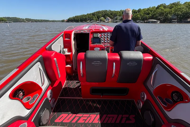 Slide: The Image of 2004 Outerlimits 42 Legacy boat interior with red and black seating on a lake. - 16