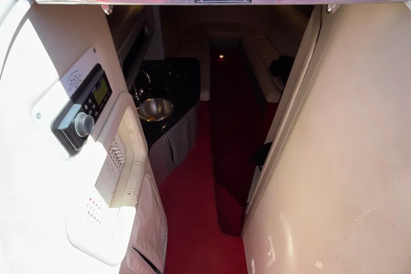 Slide: The Image of Interior of 2004 Outerlimits 42 Legacy boat with red carpet and compact kitchenette. - 20