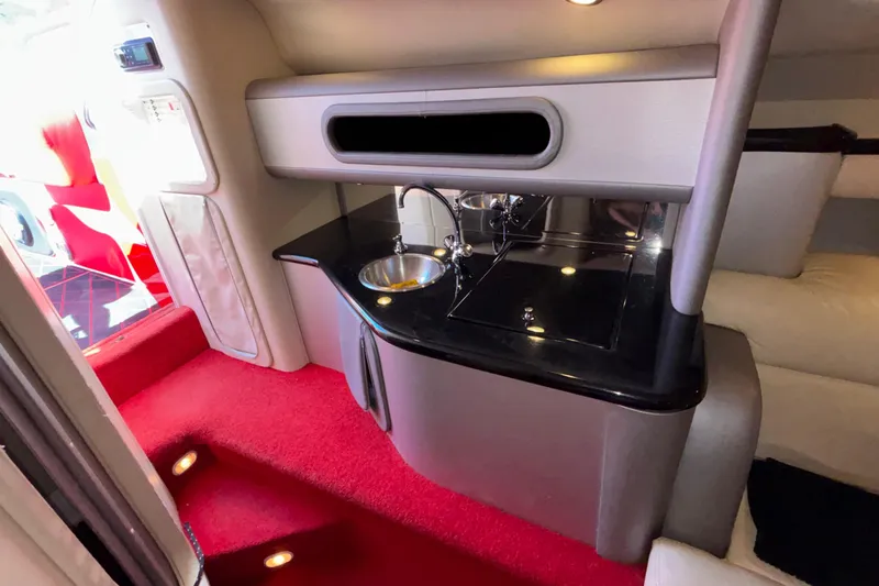 Slide: The Image of Interior of 2004 Outerlimits 42 Legacy boat with red carpet and compact kitchenette. - 23