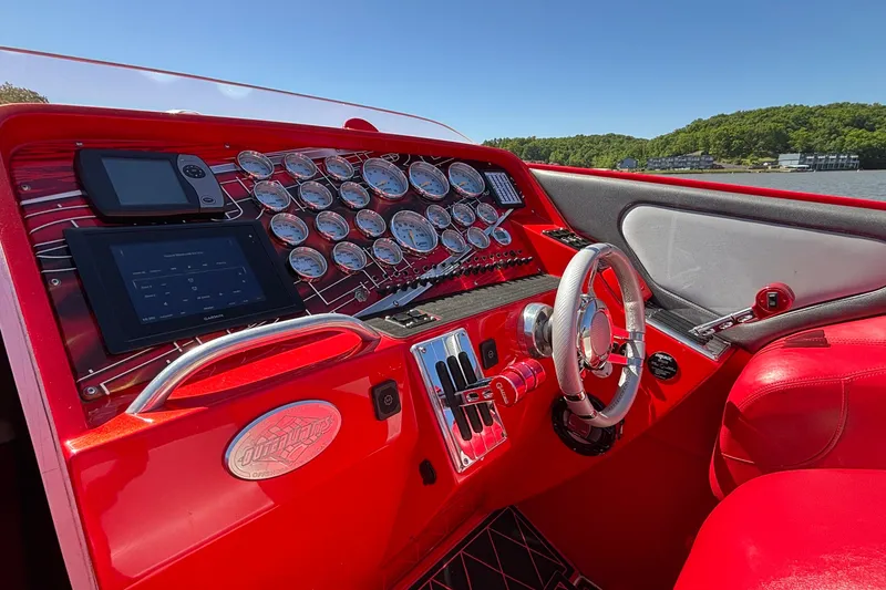 Slide: The Image of Red cockpit of 2004 Outerlimits 42 Legacy boat with gauges and steering wheel. - 33