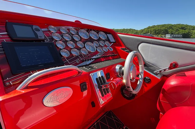 Slide: The Image of Red cockpit of 2004 Outerlimits 42 Legacy boat with gauges and steering wheel. - 34