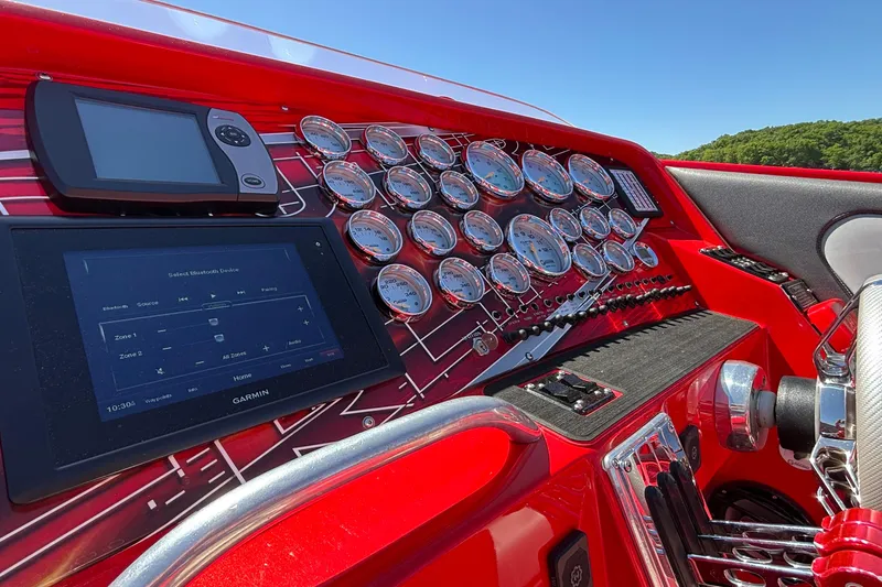 Slide: The Image of Dashboard of a 2004 Outerlimits 42 Legacy boat with multiple gauges and Garmin display. - 35