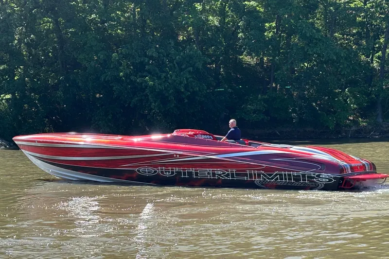 Slide: The Image of 2004 Outerlimits 42 Legacy speedboat cruising on a river, surrounded by lush greenery. - 4