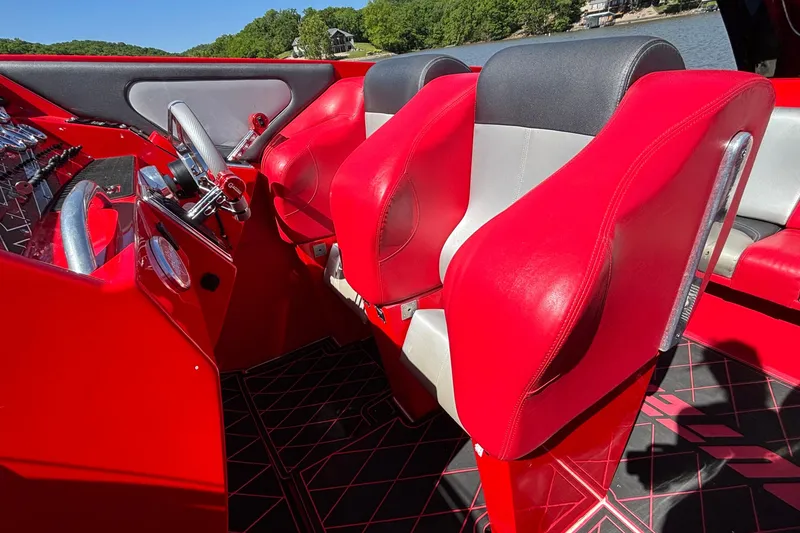 Slide: The Image of Red and gray cockpit interior of 2004 Outerlimits 42 Legacy boat, featuring sleek design and controls. - 43