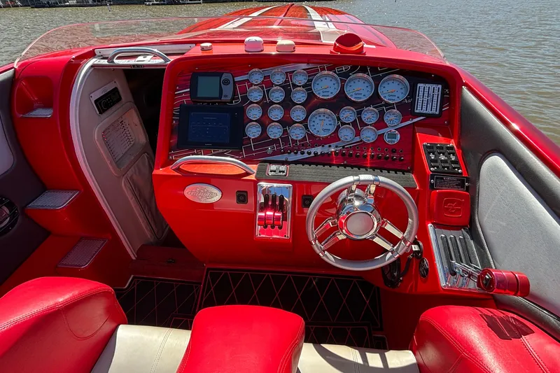 Slide: The Image of 2004 Outerlimits 42 Legacy boat cockpit with red interior and advanced control panel. - 45