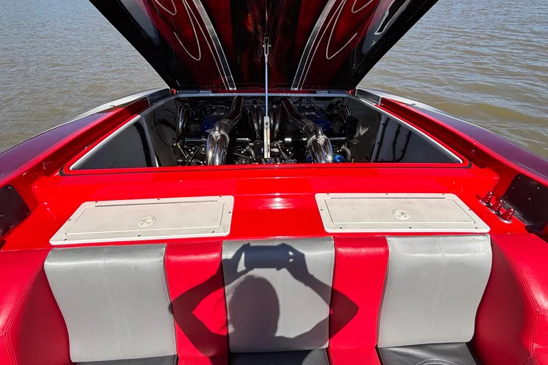 Slide: The Image of 2004 Outerlimits 42 Legacy boat engine compartment with red and gray seating, open hatch. - 48