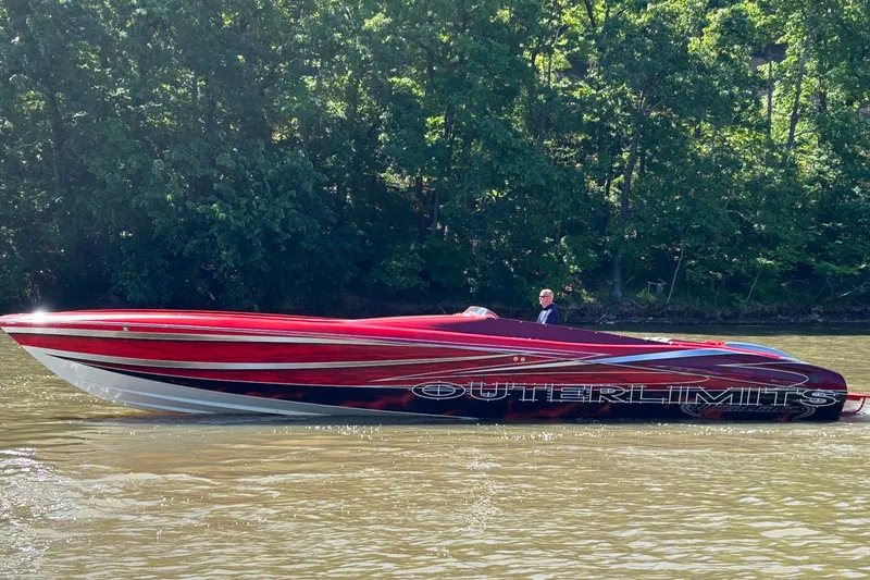 Slide: The Image of Red 2004 Outerlimits 42 Legacy speedboat cruising on a river with lush green trees in the background. - 5