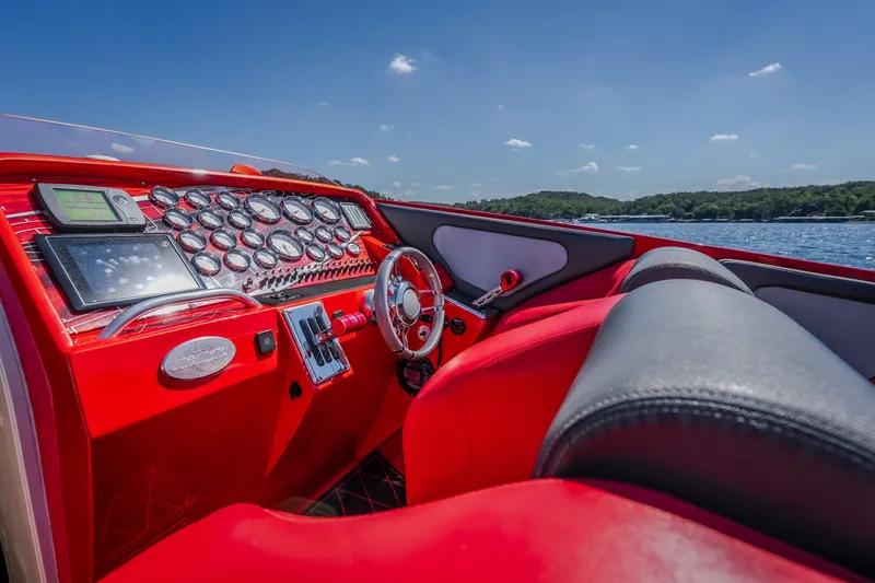 Slide: The Image of 2004 Outerlimits 42 Legacy boat cockpit with red interior and detailed dashboard controls. - 21