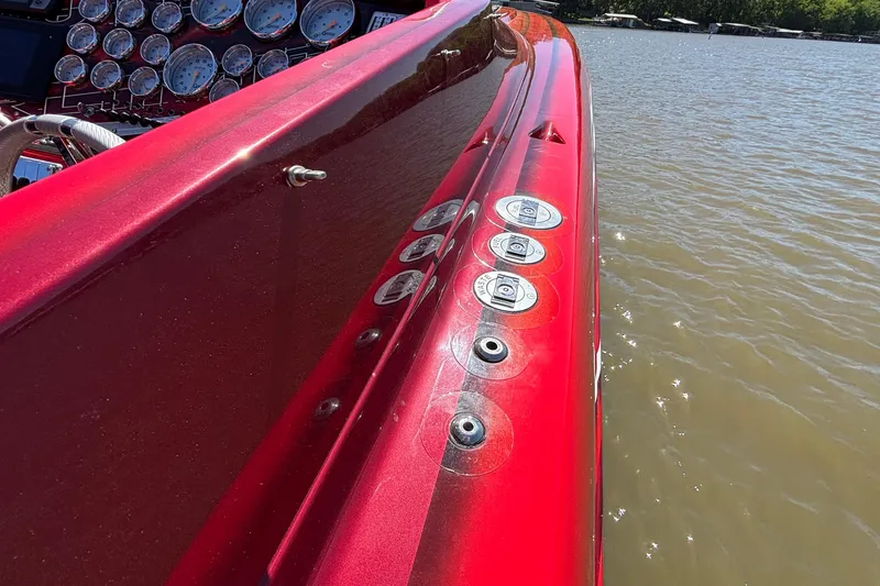 Slide: The Image of Red 2004 Outerlimits 42 Legacy boat dashboard with gauges, docked on a sunny day. - 59