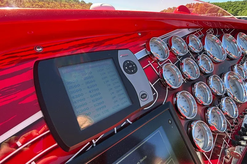 Slide: The Image of Dashboard of a 2004 Outerlimits 42 Legacy boat with multiple gauges and digital display. - 60