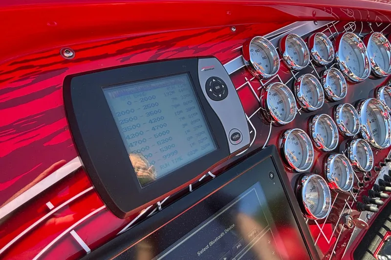 Slide: The Image of Dashboard of a 2004 Outerlimits 42 Legacy boat with multiple gauges and digital displays. - 61