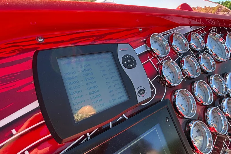 Slide: The Image of Dashboard of a 2004 Outerlimits 42 Legacy boat with gauges and digital display. - 62