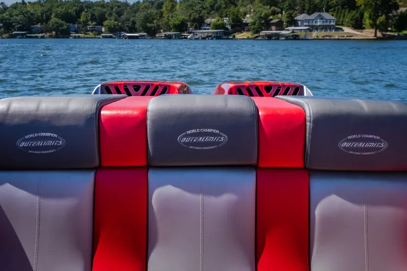 Slide: The Image of 2004 Outerlimits 42 Legacy boat seats with logo, on a lake with houses in the background. - 42