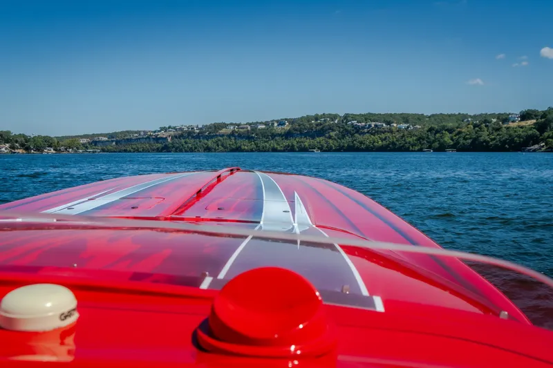 Slide: The Image of 2004 Outerlimits 42 Legacy boat cruising on a scenic lake under a clear blue sky. - 29