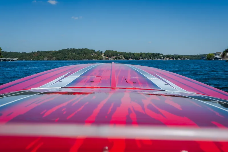 Slide: The Image of 2004 Outerlimits 42 Legacy boat with vibrant red and silver design on a serene lake. - 31