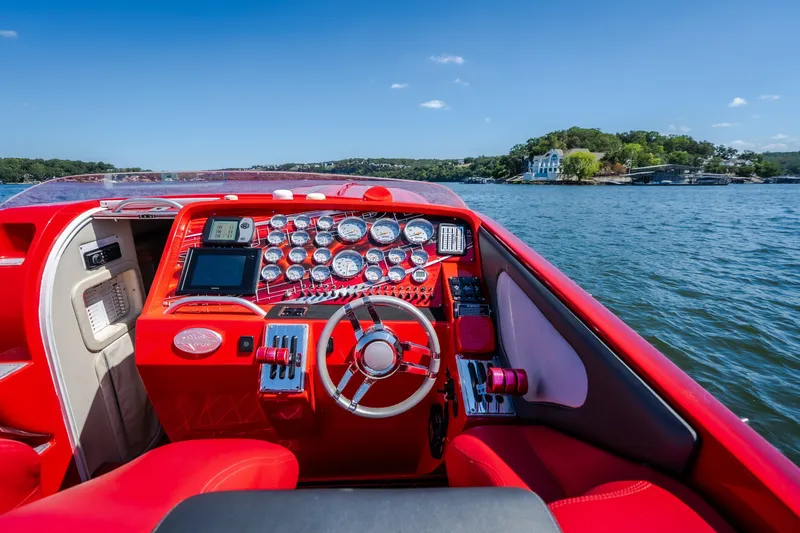 Slide: The Image of Red 2004 Outerlimits 42 Legacy boat dashboard with gauges, steering wheel, and water view. - 22