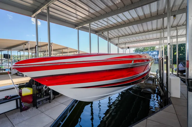 Slide: The Image of 2004 Outerlimits 42 Legacy speedboat with striking red and white design in a covered dock. - 34