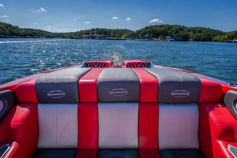 Slide: The Image of Red and gray seating on a 2004 Outerlimits 42 Legacy boat cruising on a sunny lake. - 16