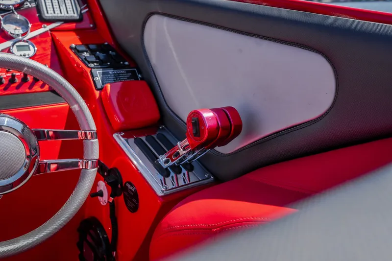 Slide: The Image of Red interior of 2004 Outerlimits 42 Legacy boat with steering wheel and controls. - 24