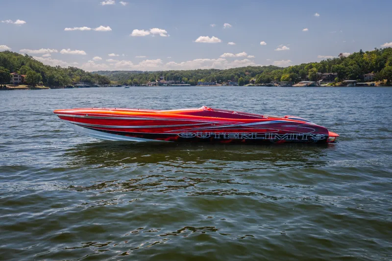 Slide: The Image of 2004 Outerlimits 42 Legacy speedboat on a scenic lake under a clear sky. - 44