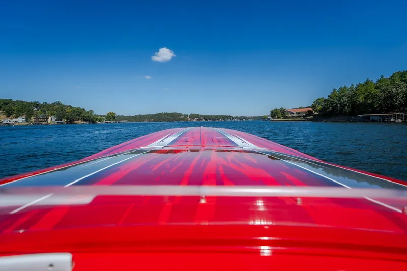 Slide: The Image of Red 2004 Outerlimits 42 Legacy boat cruising on a scenic lake under clear blue skies. - 30