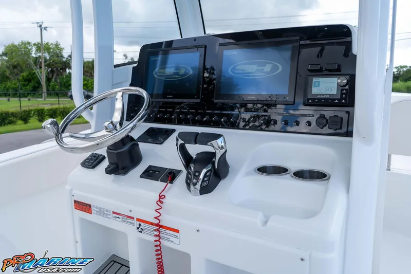 Slide: The Image of 2026 Sea Hunt Ultra 265 SE boat dashboard with steering wheel and electronic controls. - 12
