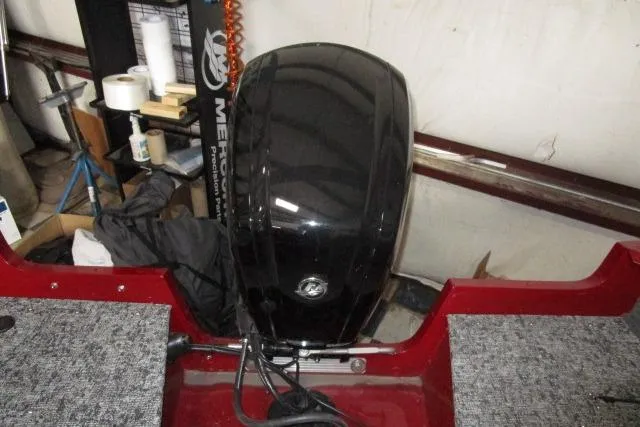 Slide: The Image of 2024 Tracker Pro Guide V-16 WT boat with a black outboard motor in a workshop setting. - 11