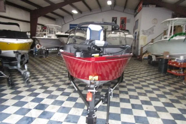 Slide: The Image of 2024 Tracker Pro Guide V-16 WT boat in showroom, red exterior, checkered floor. - 3