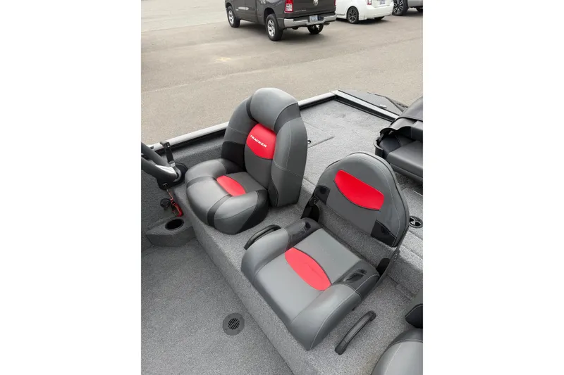 Slide: The Image of 2025 Tracker Savage 215 boat seats with gray and red upholstery in a parking lot. - 8