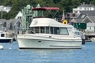 The Image of 2005 Camano Trawler boat docked in a scenic harbor with coastal buildings. - 0