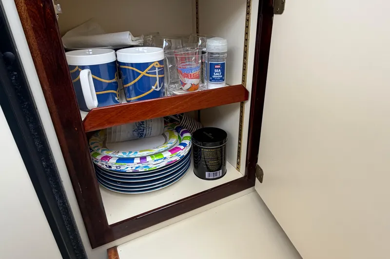 Slide: The Image of Cabinet in 2005 Camano Trawler with mugs, plates, and sea salt. - 12