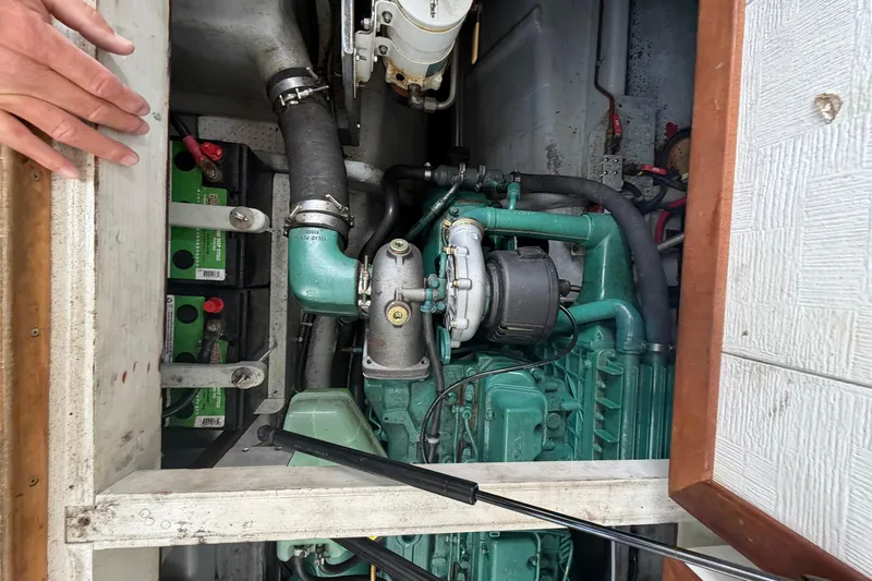 Slide: The Image of Engine compartment of a 2005 Camano Trawler, showcasing mechanical components and batteries. - 19